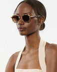 Woman wearing sunglasses with a neutral background