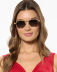 Woman wearing sunglasses with a plain background