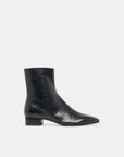 A black midi leather boot on a white background