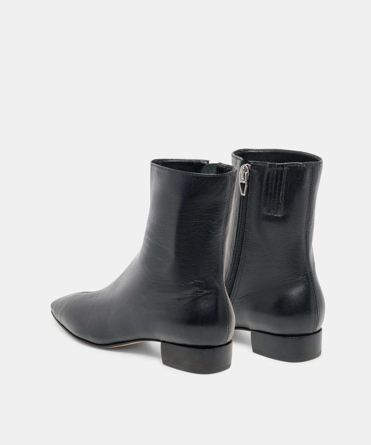 A pair of black leather ankle boots with a side zipper, shown from a rear three-quarter angle against a light gray studio background.