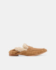 A tan suede slip-on loafer with a fluffy cream shearling lining, shown in profile against a light gray background.