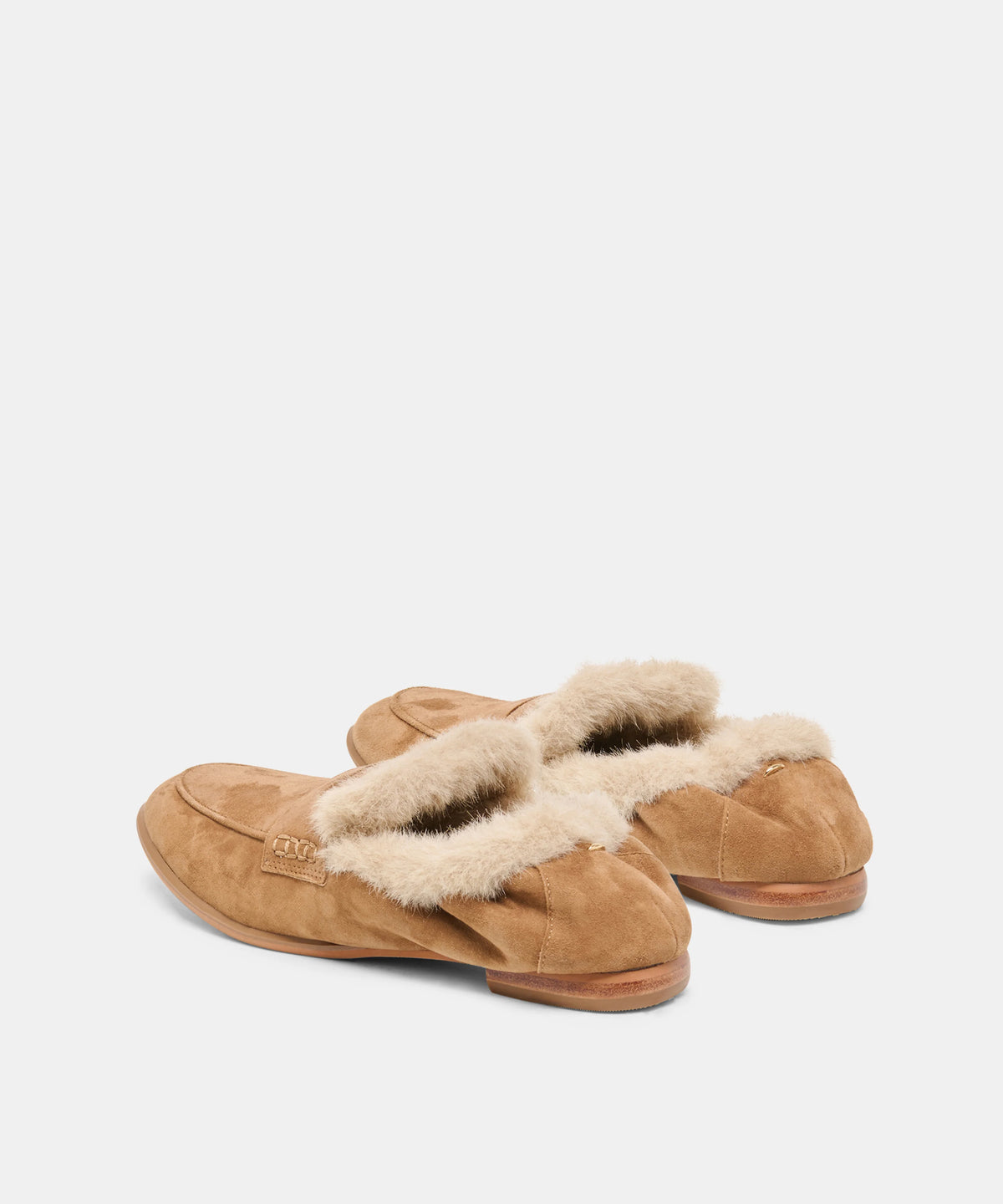 A pair of tan suede slip-on slippers with fluffy cream shearling lining, shown from a side angle on a light gray background.