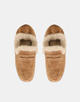 A pair of tan suede slip-on loafers with a thick cream shearling-style lining, shown from a top-down view on a light gray background.