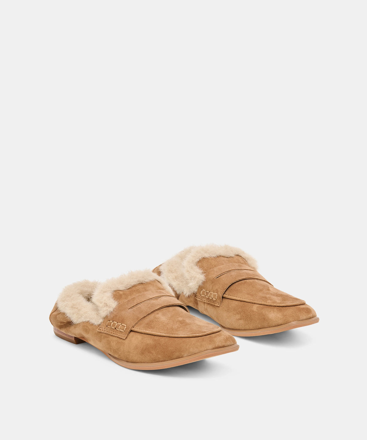 A pair of tan suede slip-on loafers with fluffy cream shearling lining, displayed on a clean light gray background.