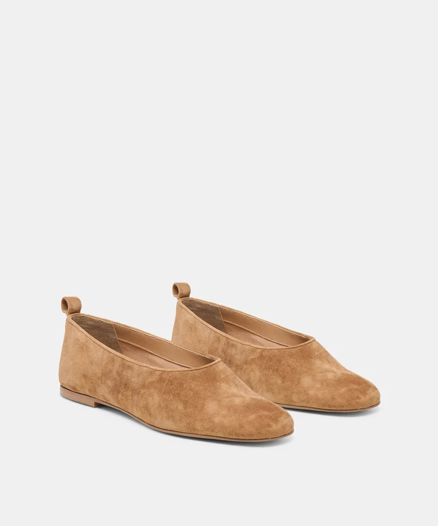 A pair of tan suede flat shoes with pull tabs, shown from a three-quarters angle on a light gray background.
