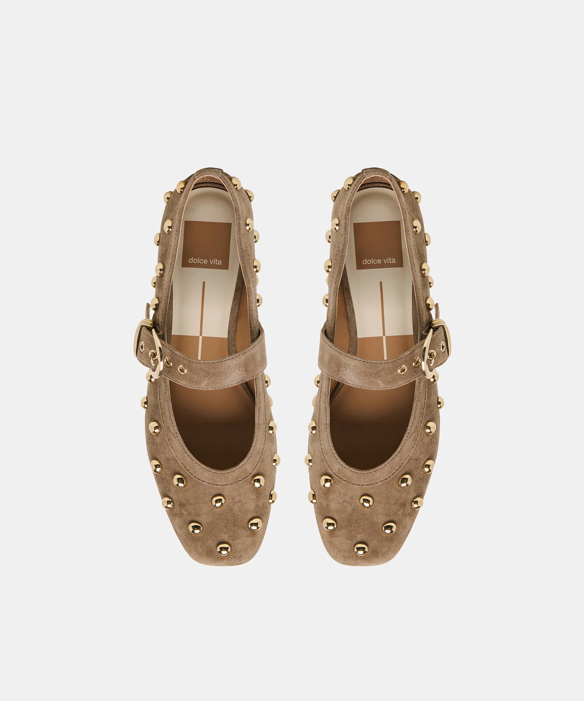 A pair of taupe-brown suede Mary Jane shoes with gold-tone studs and buckle straps, shown from a top-down view on a light gray background.