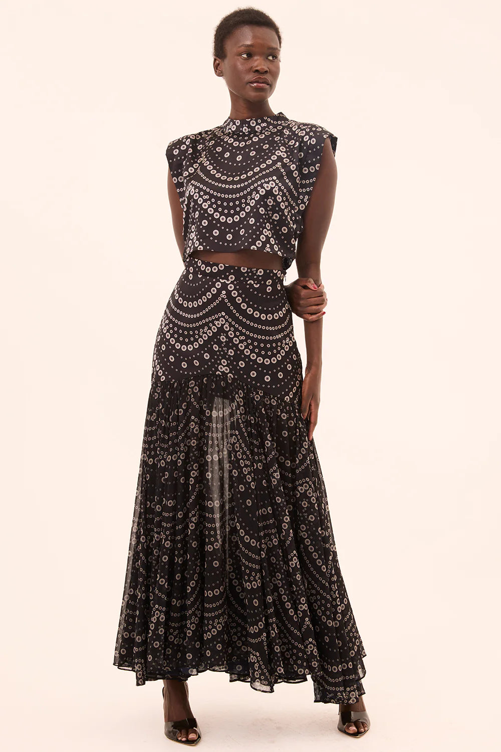 model wearing the yara skirt in stranded pearl with a matching top on a cream background