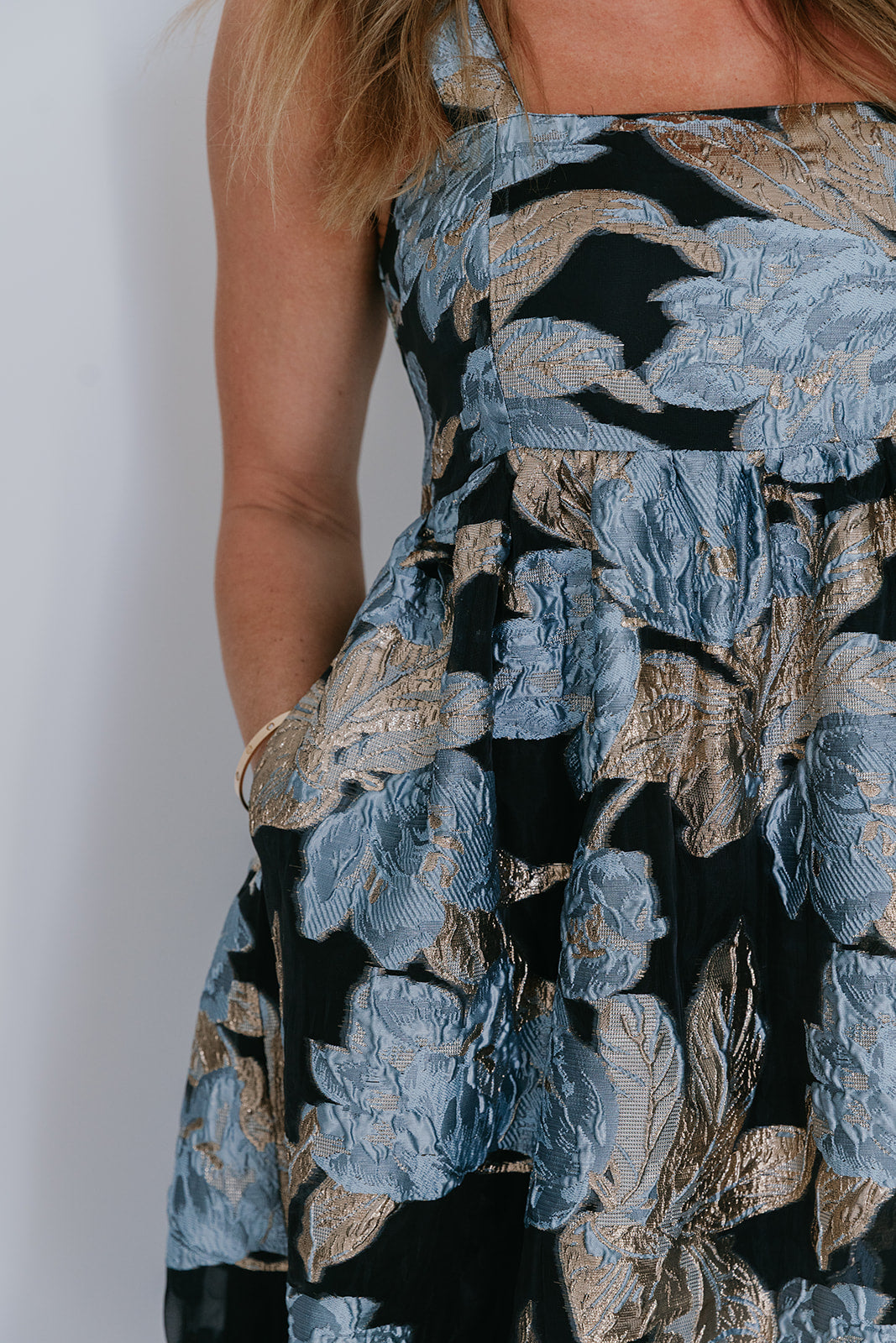 Close-up of a floral dress with blue and black pattern on a plain background