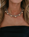 Close-up of a necklace with gold and silver beads worn by a person with blonde hair.
