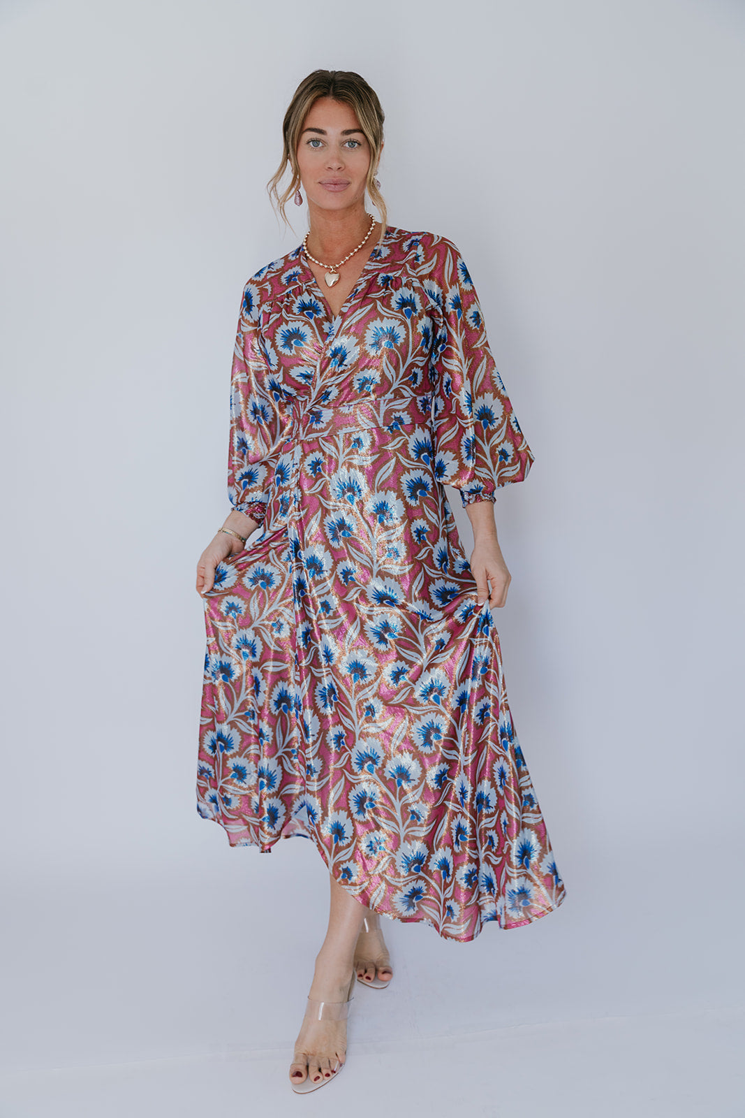 Woman wearing a floral dress on a white background, full body