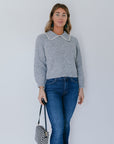 model wearing grey crochet collar cardigan with jeans on a white background