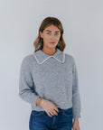 model wearing grey crochet collar cardigan with jeans on a white background