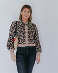 model wearing the leopard windsor cardigan with jeans and a shearling bag with a heart fob on a white background, front