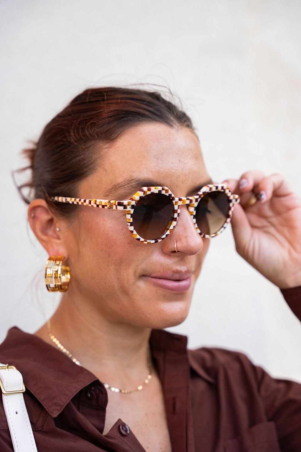Woman wearing sunglasses with a plain background