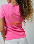 Person wearing a pink t-shirt with a graphic design on the back, standing against a plain background.