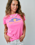 Woman wearing a pink t-shirt with 'Day Camp' text and sun graphic on a plain background