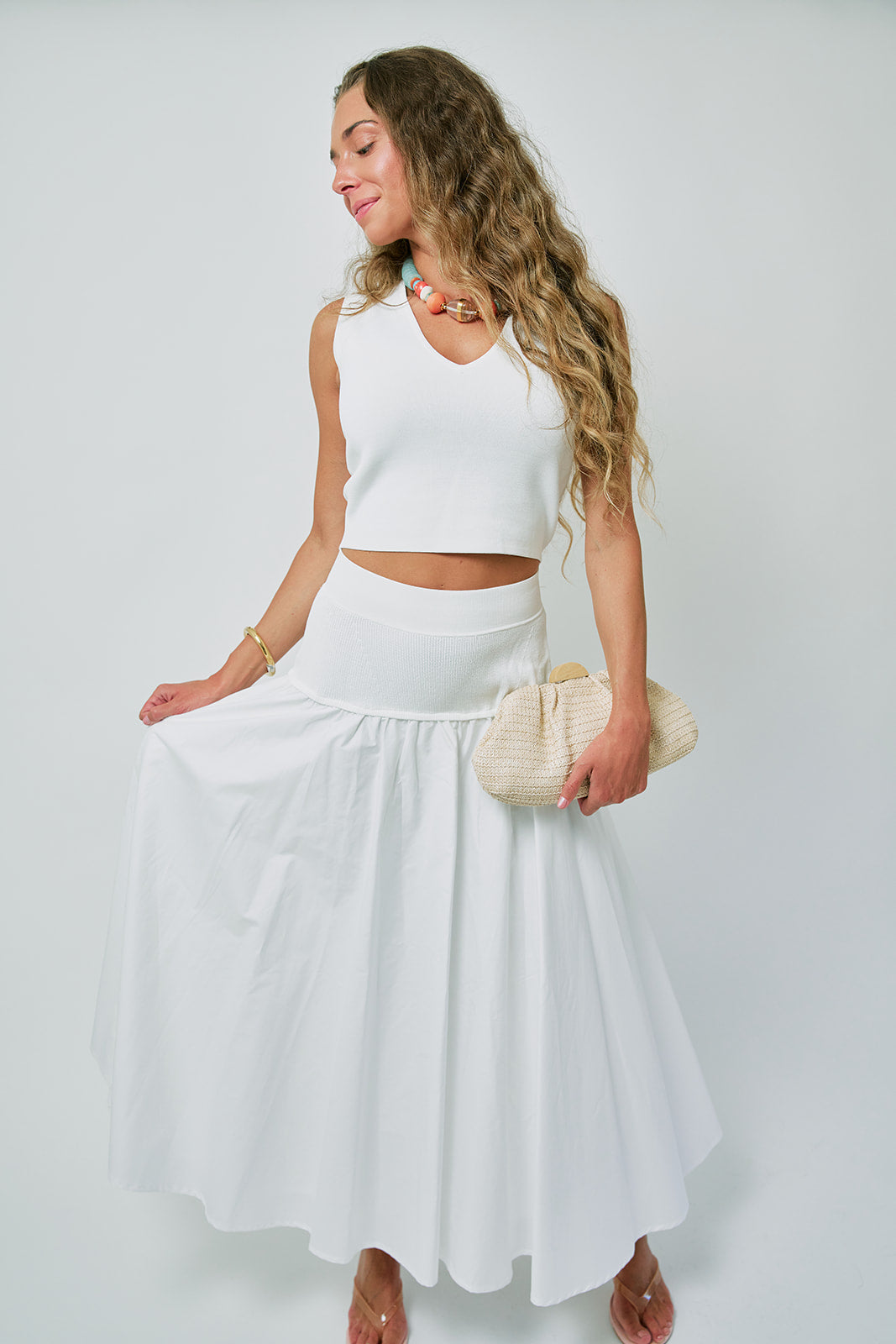 Woman wearing a white outfit with a plain background