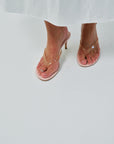 Pink high-heeled sandals on a white background