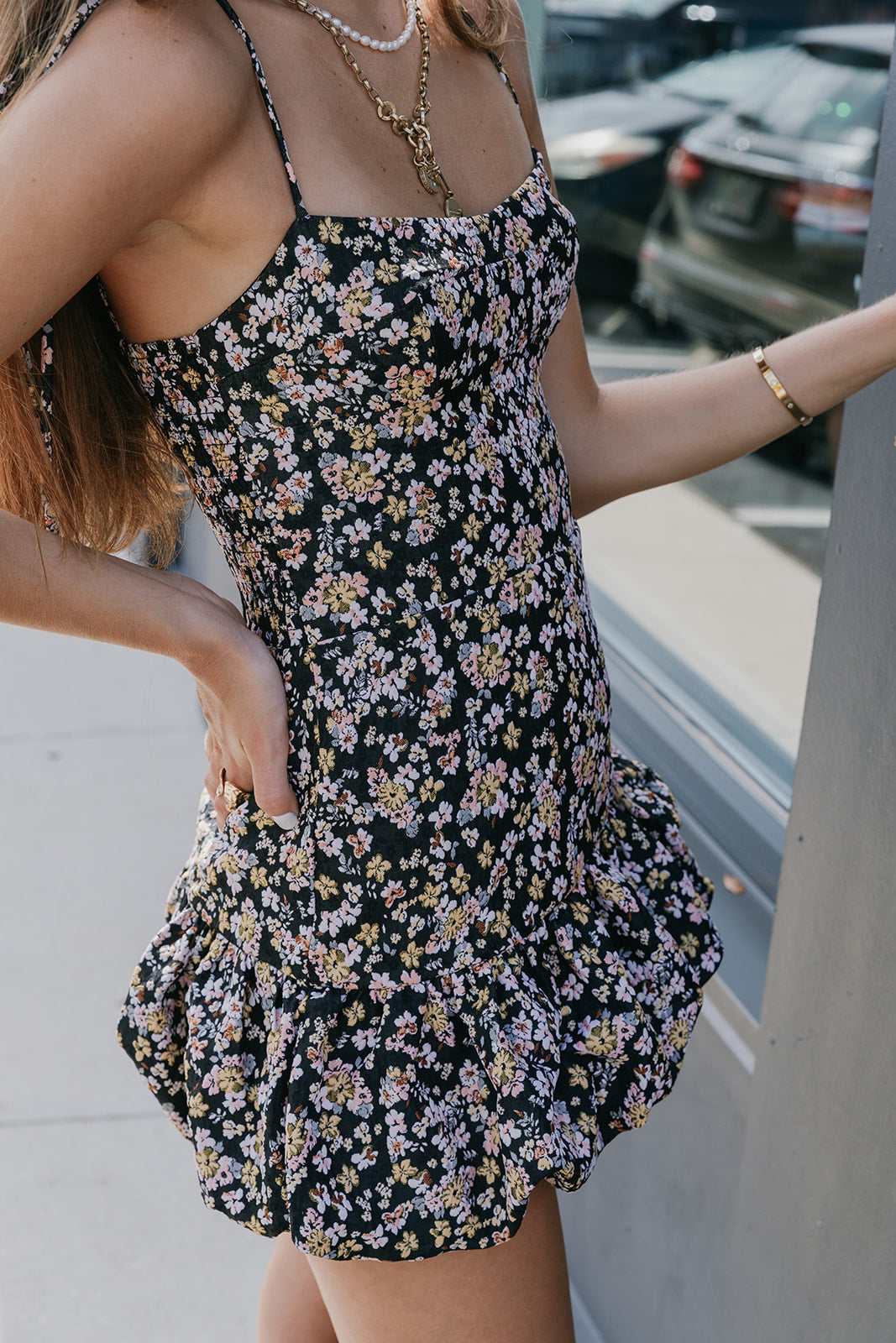 Close up of side view of a woman wearing Ivy Skort Bubble dress standing by a window 
