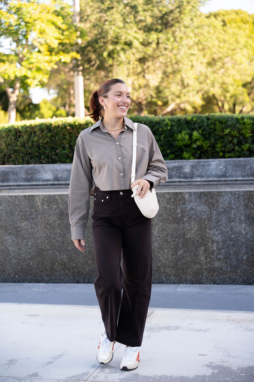 Woman walking outdoors with a cream handbag, wearing Anna Cropped Shirt Plaid and Miro Jean.