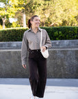 Woman walking outdoors with a cream handbag, wearing Anna Cropped Shirt Plaid and Miro Jean.