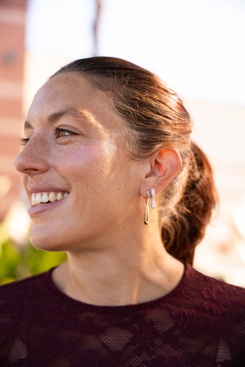 Woman with a side profile, wearing earrings, with a blurred background