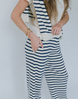 Person wearing a white and navy striped outfit against a plain background