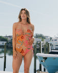 Model wearing Oceana One Piece with boats in background, front view