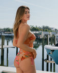 Model wearing Oceana One Piece with boats in background, back view