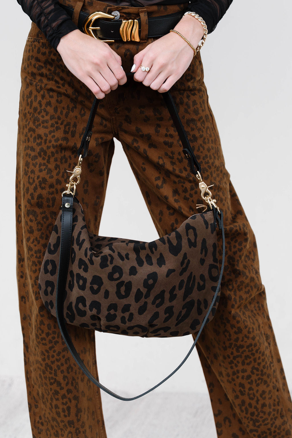 Person wearing leopard print pants holding Moyen Messenger in Cocoa Pablo Cat