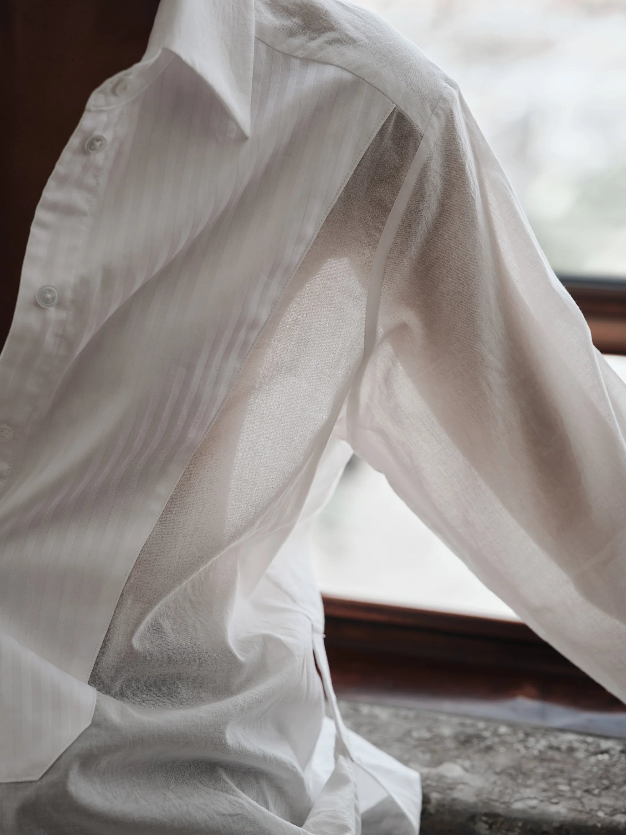 White shirt with sheer overlay draped over a surface