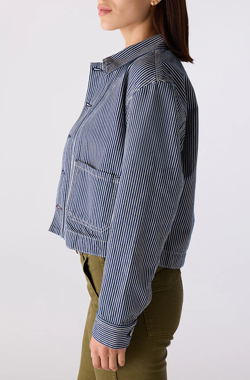 Person wearing a blue and white striped shirt with a white background