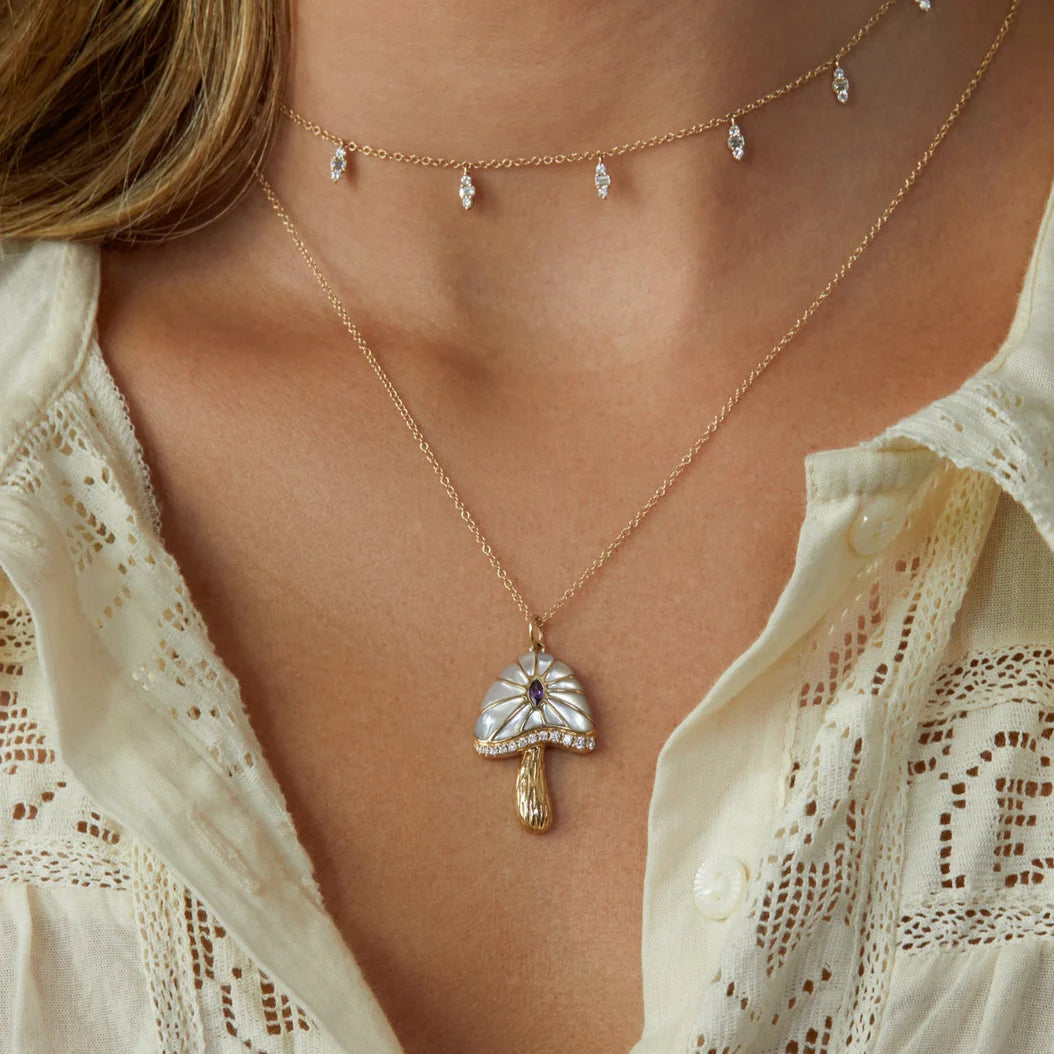 Necklace with a pendant worn by a person against a neutral background