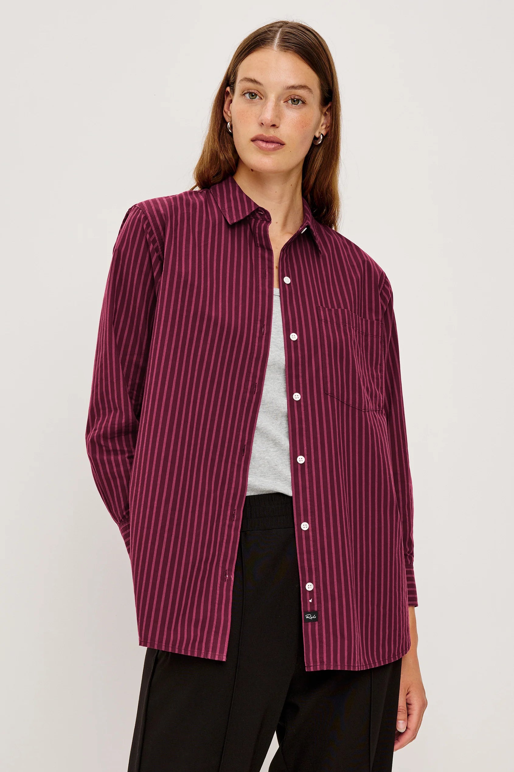 Woman wearing a burgundy striped shirt on a white background front view