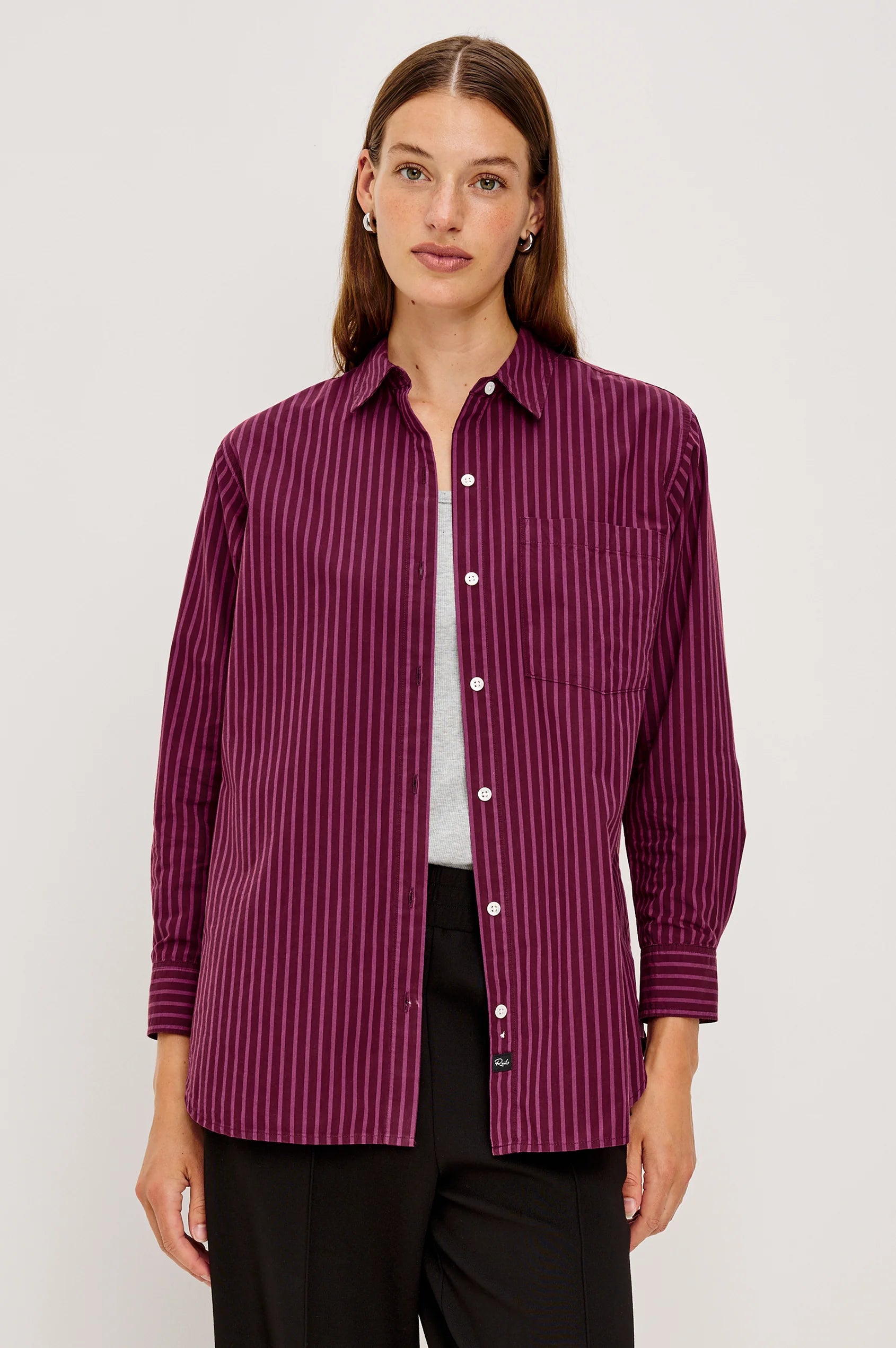 Woman wearing a purple striped shirt on a white background front view
