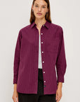 Woman wearing a purple striped shirt on a white background front view