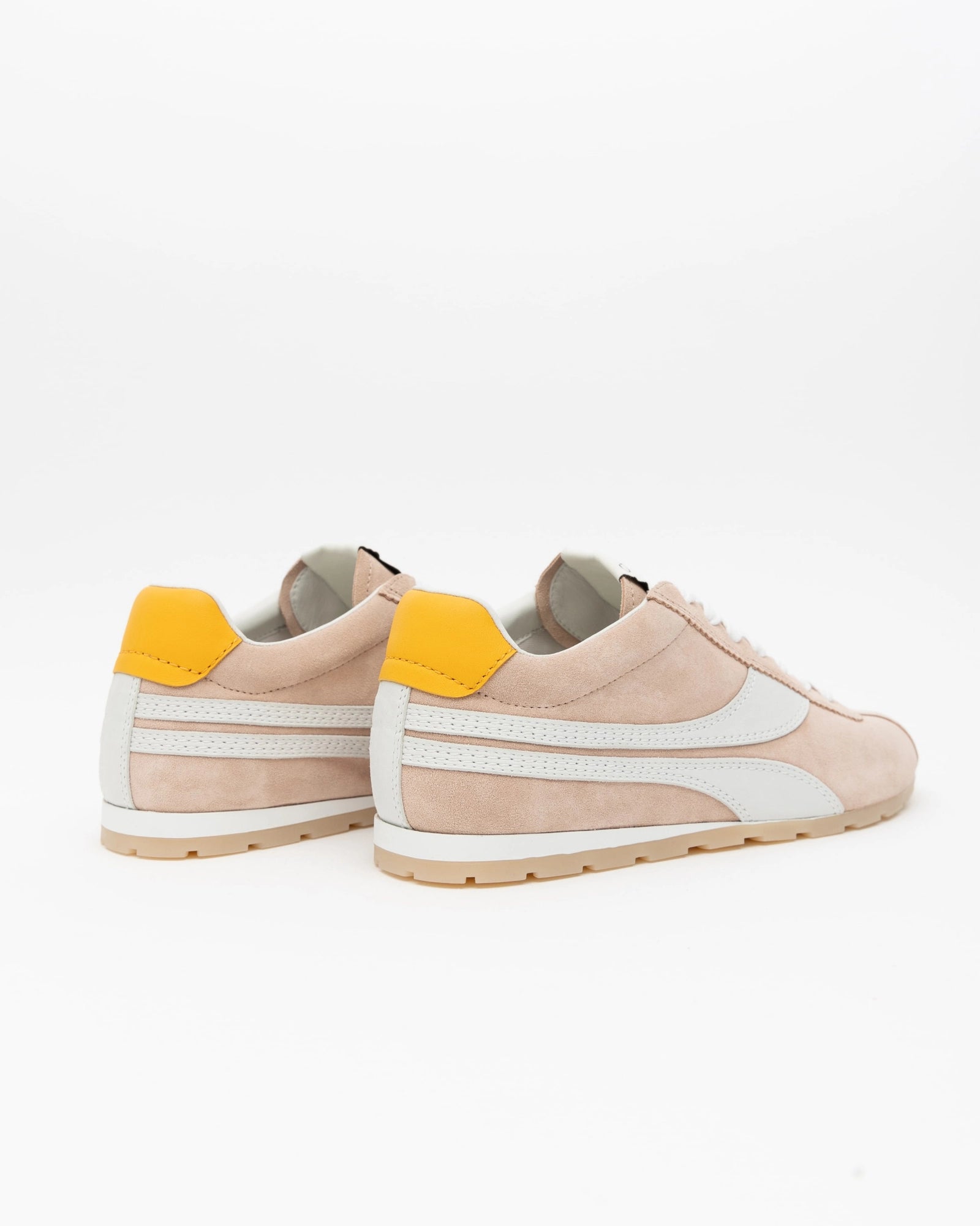 Pair of pink sneakers with white stripes and yellow accents on a light gray background, back view