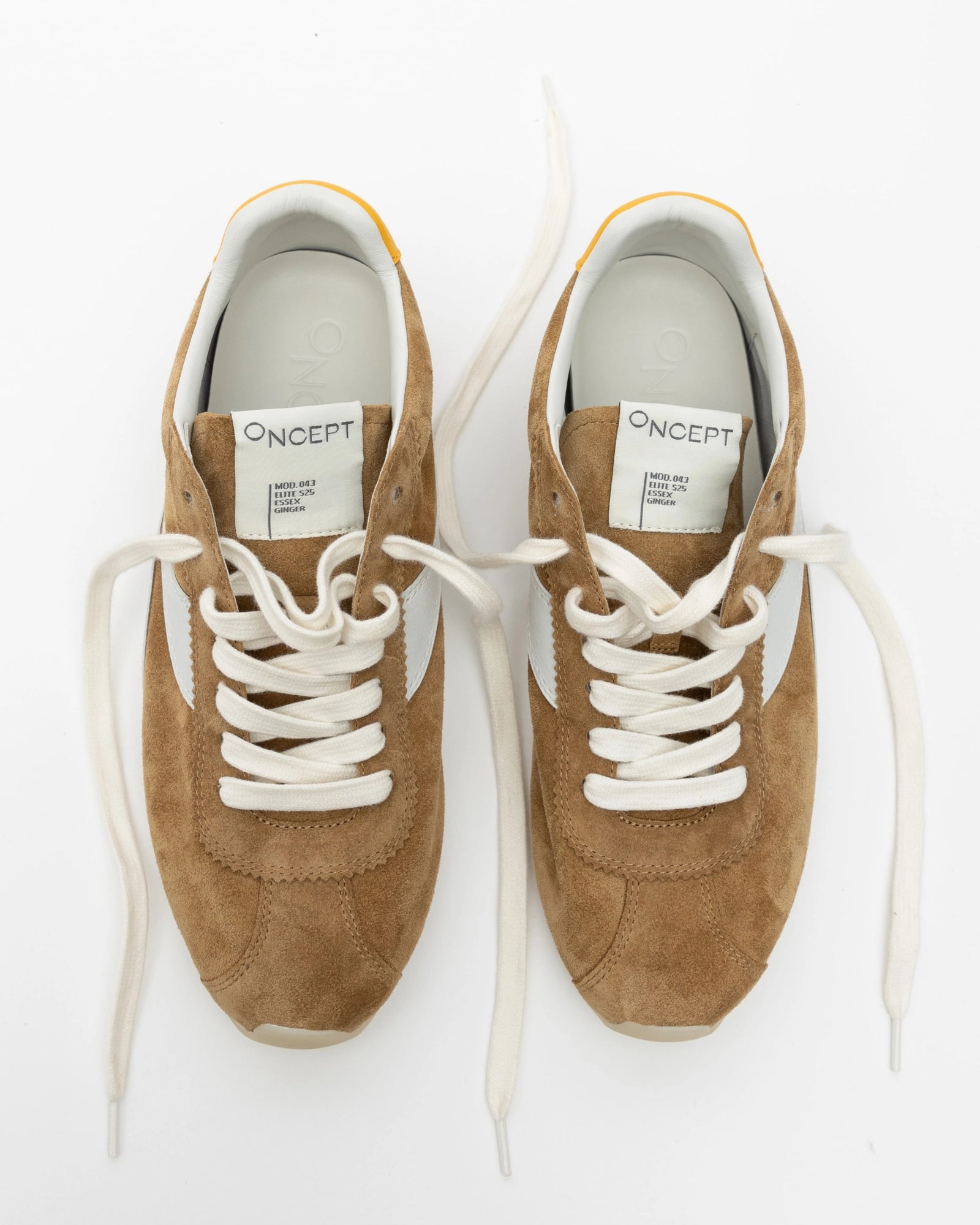 Pair of brown sneakers with white laces on a white background