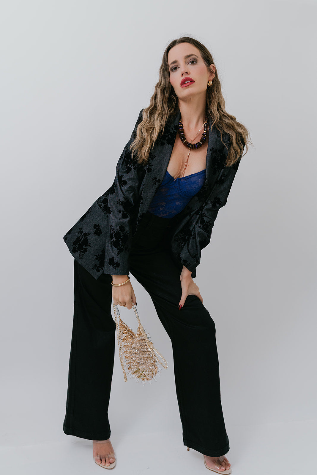 Woman in a black and blue outfit with Florence Chainmail Bag and a white background