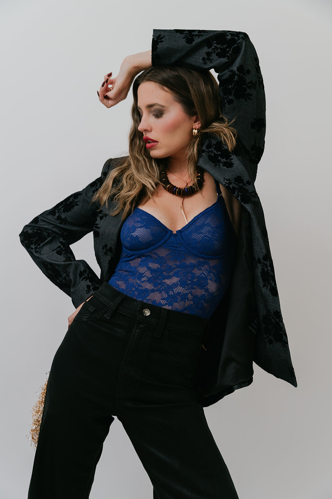 Woman wearing Grady Blazer and blue lace top against a plain background