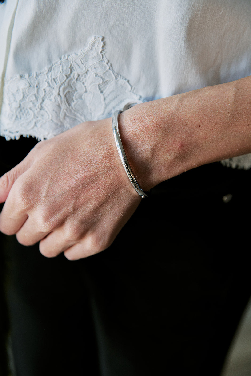 model wearing thin silver bangle 