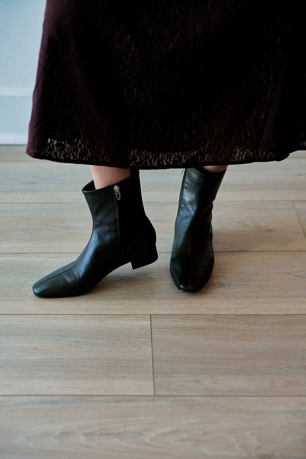 model wearing black zip inside boots with a lace dress 