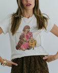 Woman wearing a white t-shirt with a graphic design of a woman sitting with two dogs