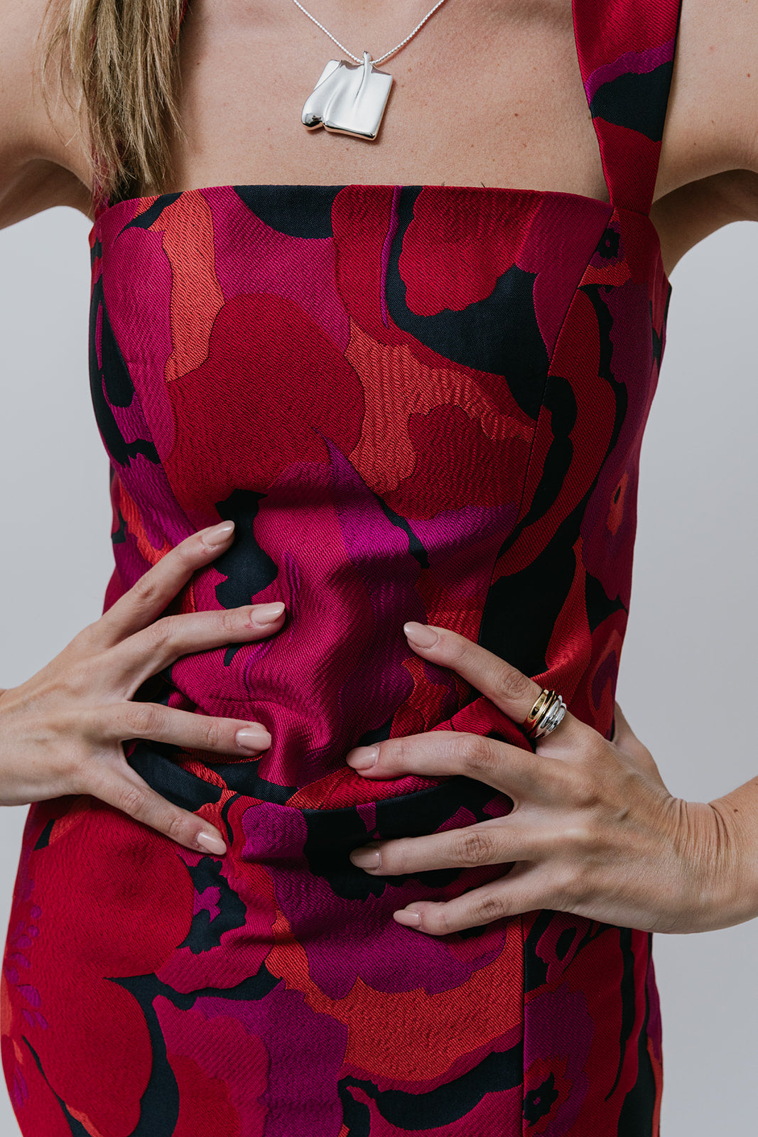 Person wearing a vibrant red and black patterned set with a plain background