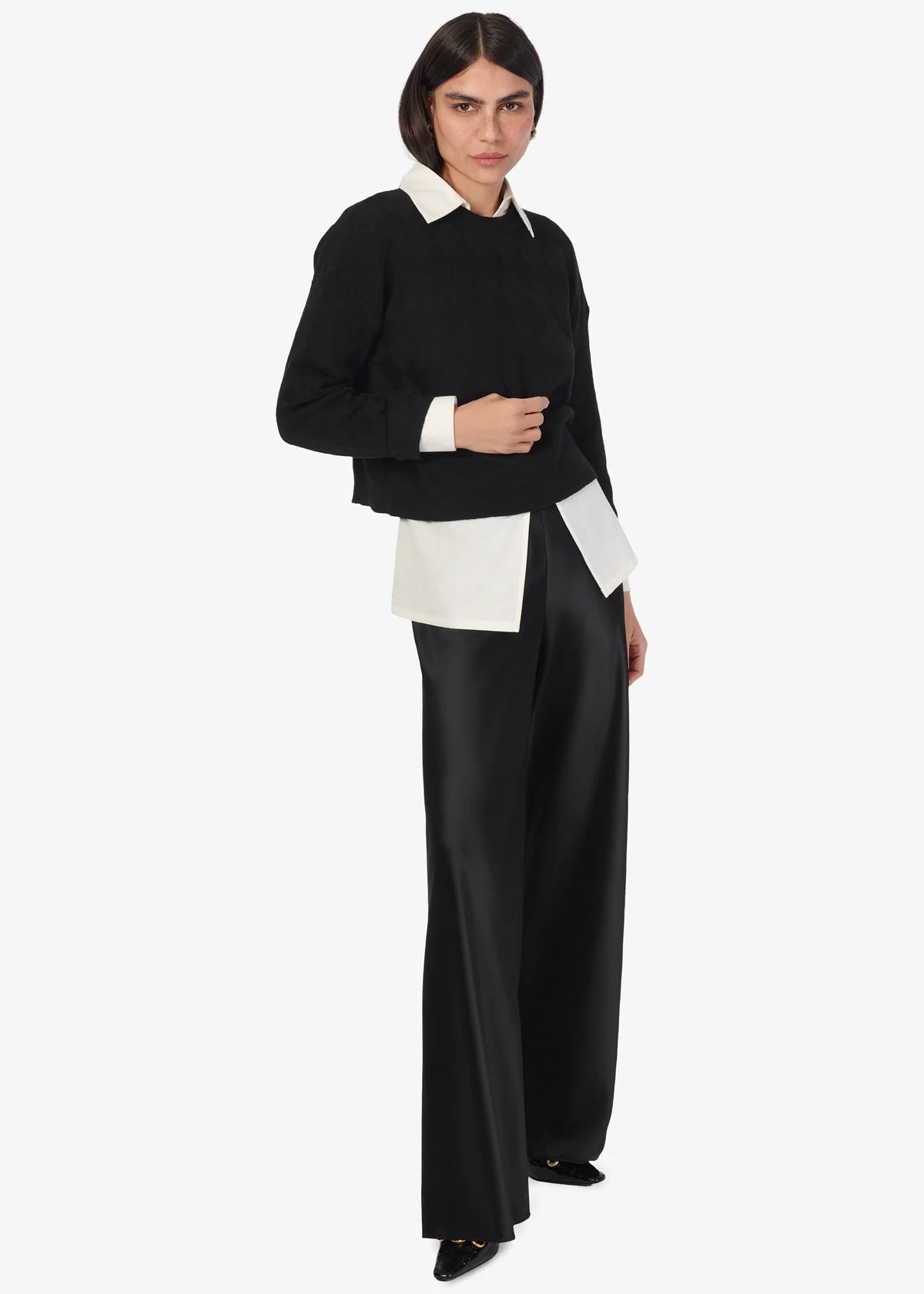 Person wearing a black and white outfit on a white background