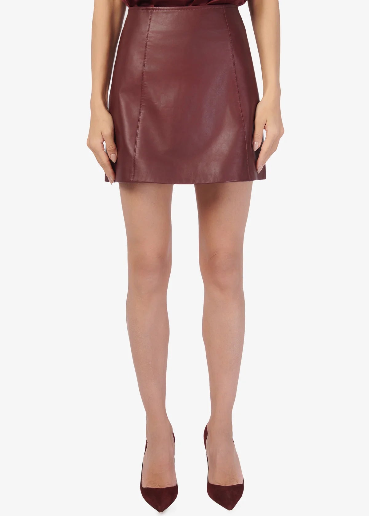 Person wearing a burgundy leather skirt on a white background
