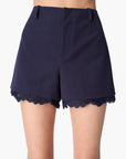 Navy blue shorts with lace trim on a white background