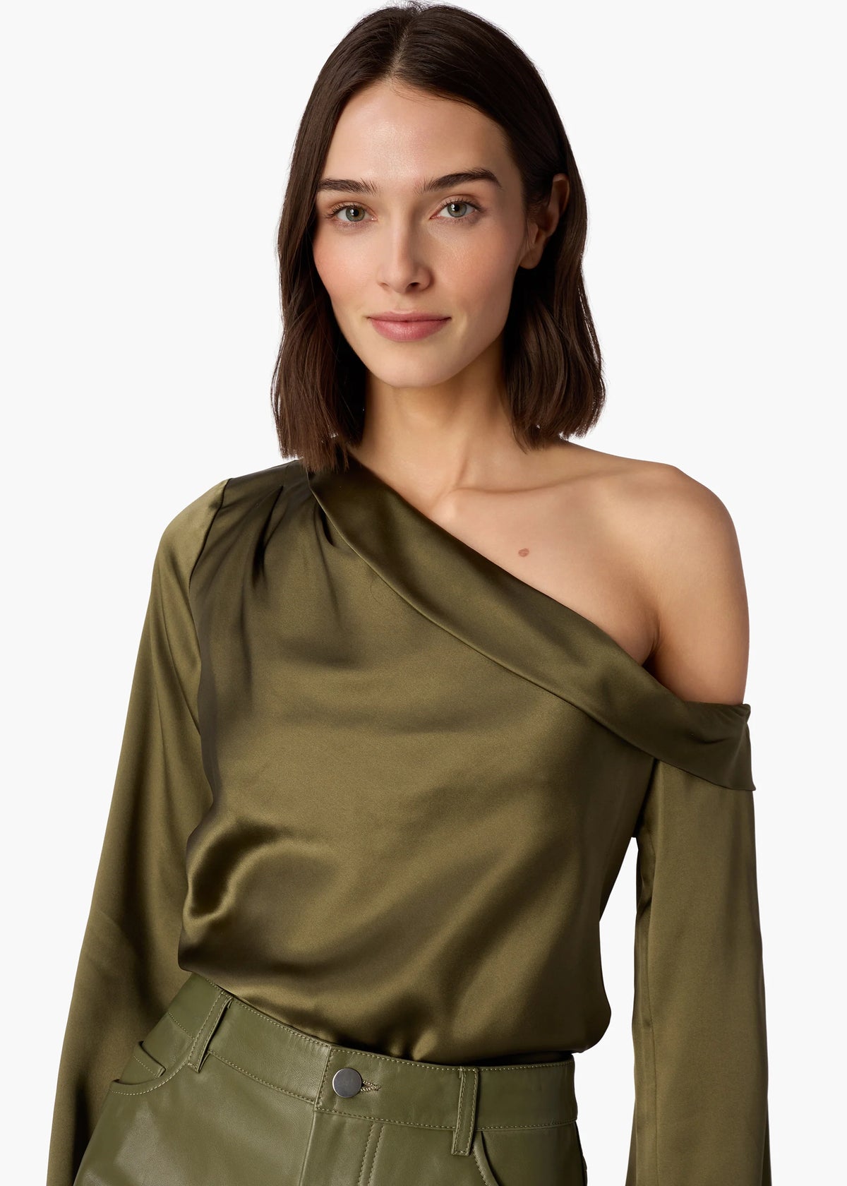 Woman wearing an olive green one-shoulder top and pants on a white background