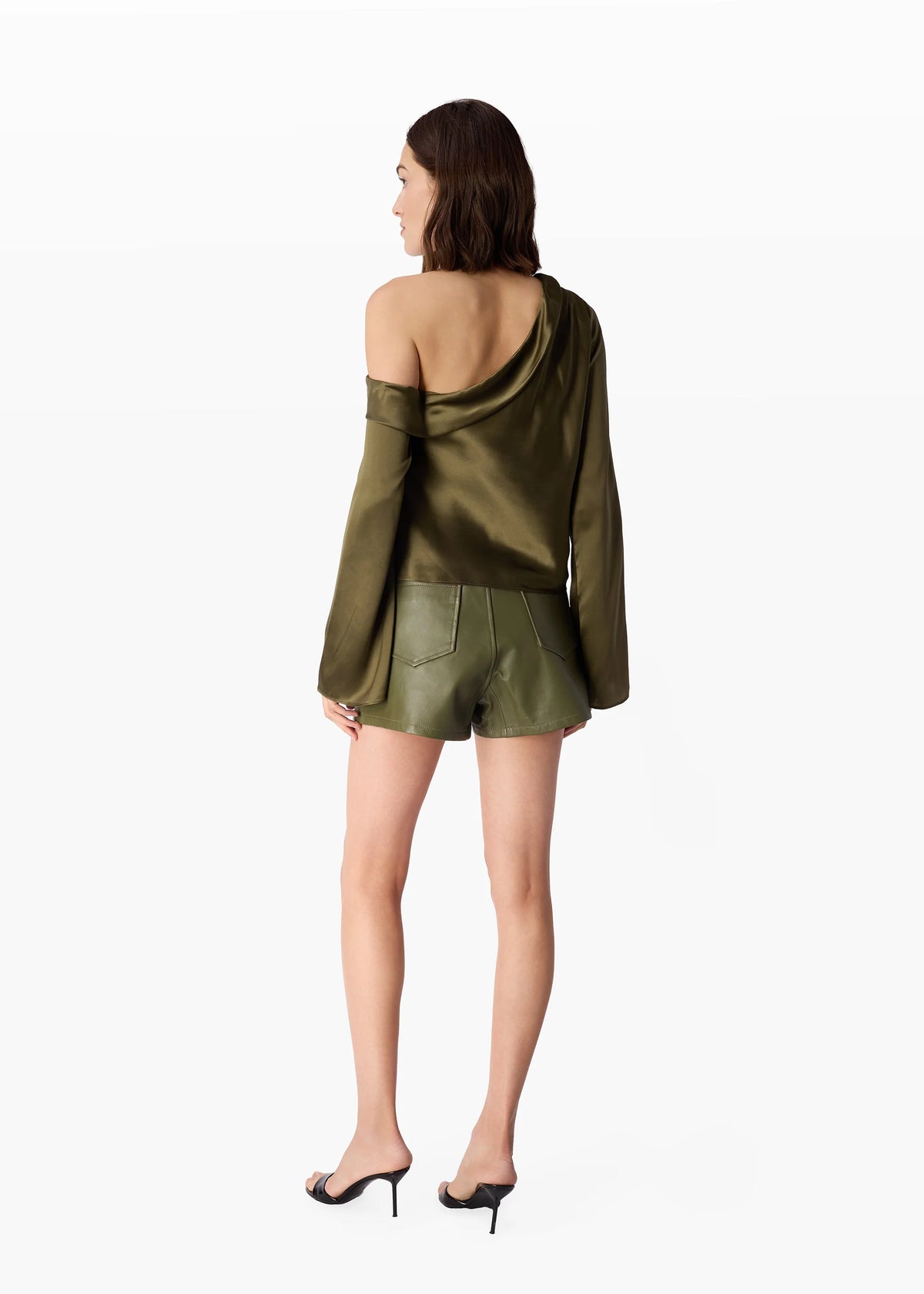 Woman wearing a green off-shoulder top and shorts on a white background