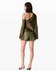 Woman wearing a green off-shoulder top and shorts on a white background